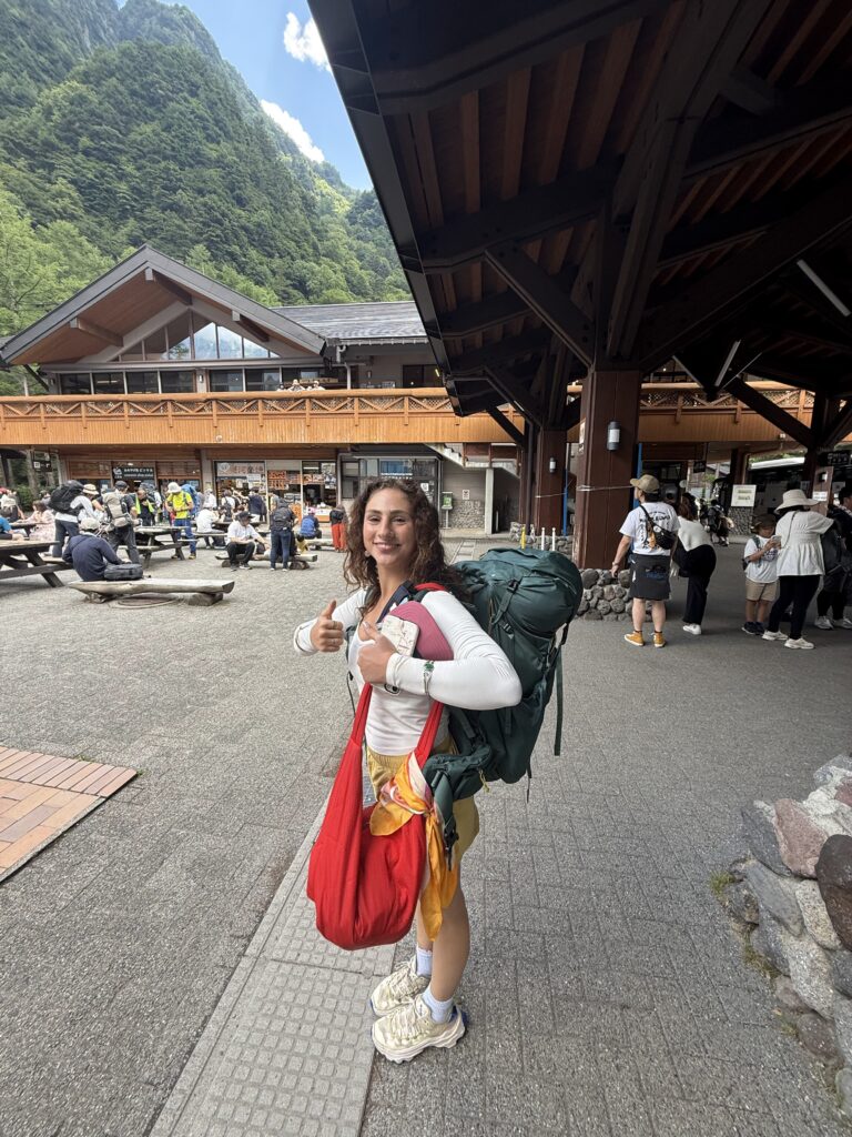 Arriving at Kamikochi National Park Young woman just arriving at Kamikochi National Park before checking in her bags to hike the beautiful surroundings.