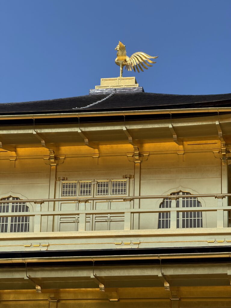 Golden Phoenix on Kinkaku-ji Rooftop, Kyoto Close-up of the golden phoenix atop Kinkaku-ji, the Golden Pavilion in Kyoto, Japan, against a clear blue sky