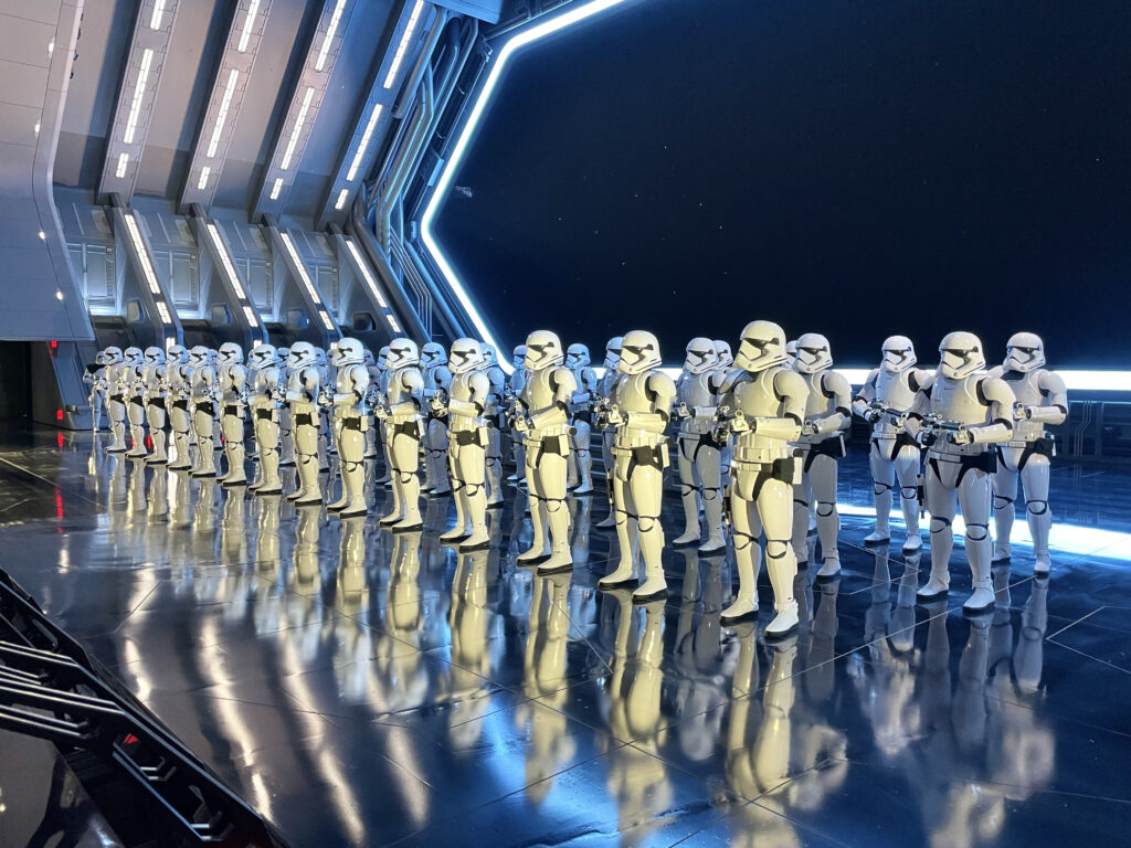 Rows of First Order Stormtroopers standing in formation inside the Star Wars: Rise of the Resistance attraction hangar.
