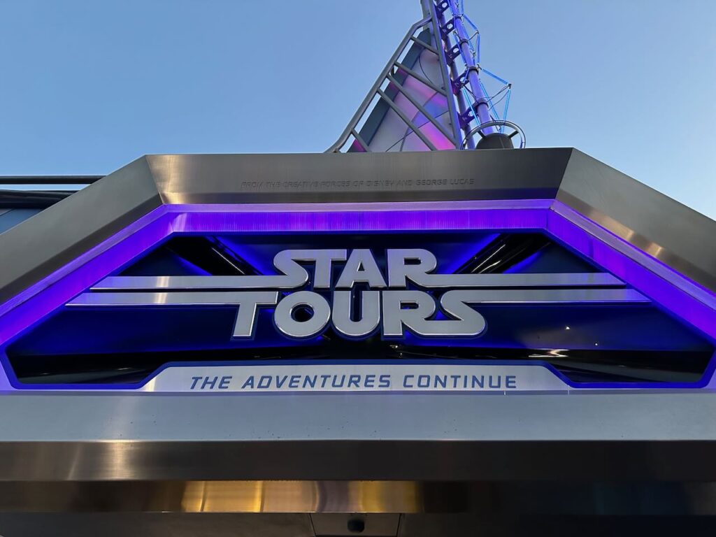 The metallic and neon blue entrance sign for Star Tours: The Adventures Continue.