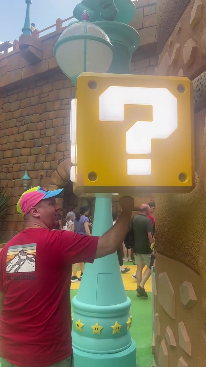 Man punching interactive question block Universal for Gamers at Epic Universe.