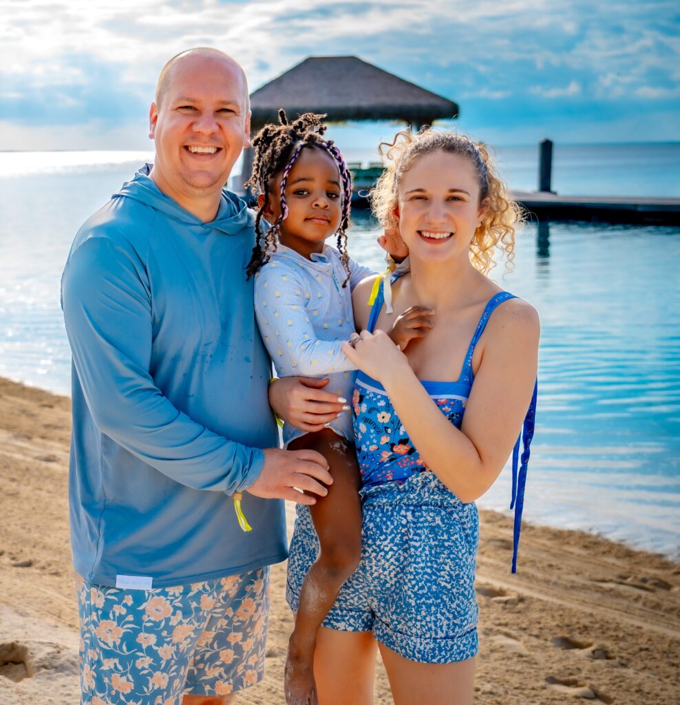 Family wearing coordinated blue swimwear during a tropical beach vacation