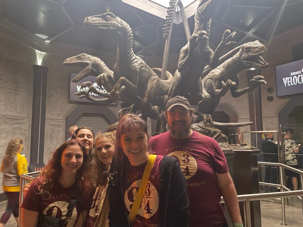 Family wearing matching Platform 9¾ shirts while waiting in line for Jurassic World VelociCoaster at Universal's Islands of Adventure